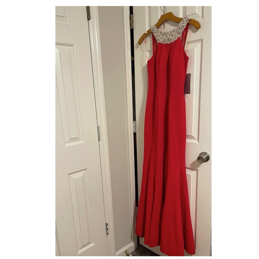 Red gown features front slit.Front and back pearls